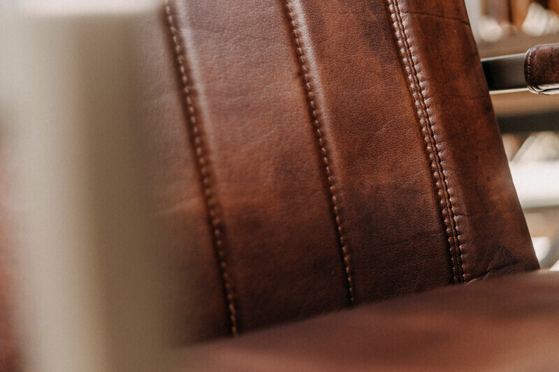 Detailansicht der genähten braunen Leder-Rückenlehne eines Freischwinger-Esszimmerstuhls