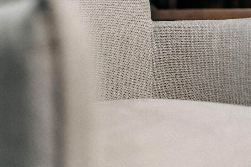 Detailfoto eines drehbaren Esszimmerstuhls aus Textil.