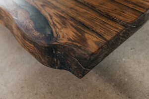 Robuste Ecke der Tischplatte aus Nussbaum im Detail mit schönen Maserungen